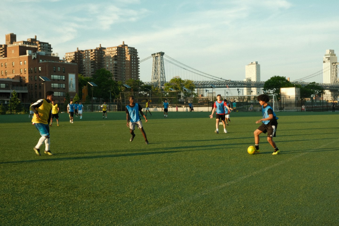 A group of soccer players competes on a city field.